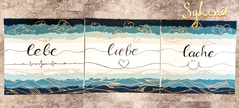 Drei elegante Wandbilder mit den Worten "Liebe", "Lache" und "Lebe" in blauen Farbtönen.